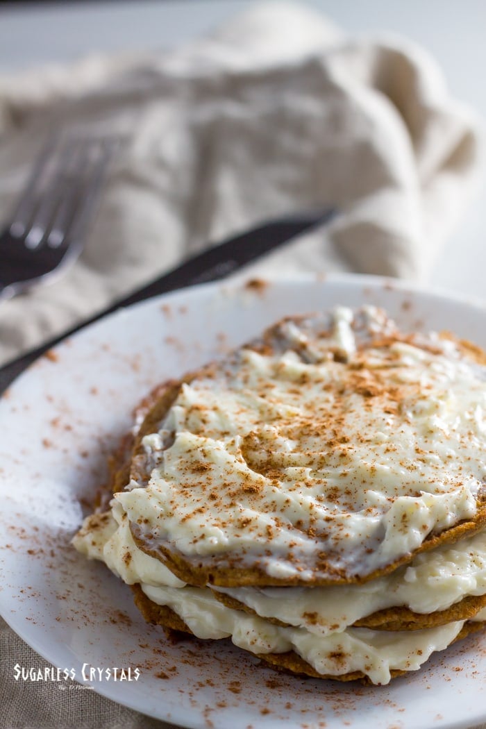 pumpkin spice keto pancakes topped with cream cheese and pumpkin spice sprinkle