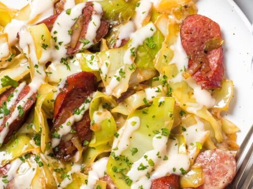 Keto Sausage And Cabbage Alfredo served with a drizzling of Alfredo sauce