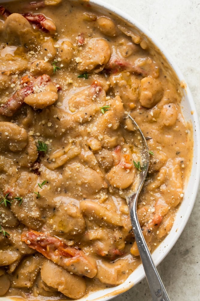 Close-up of creamy marry me butter beans with sun-dried tomatoes, Parmesan and fresh thyme